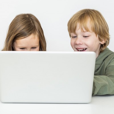 Deux enfants travaillant ensemble sur un ordinateur portable.